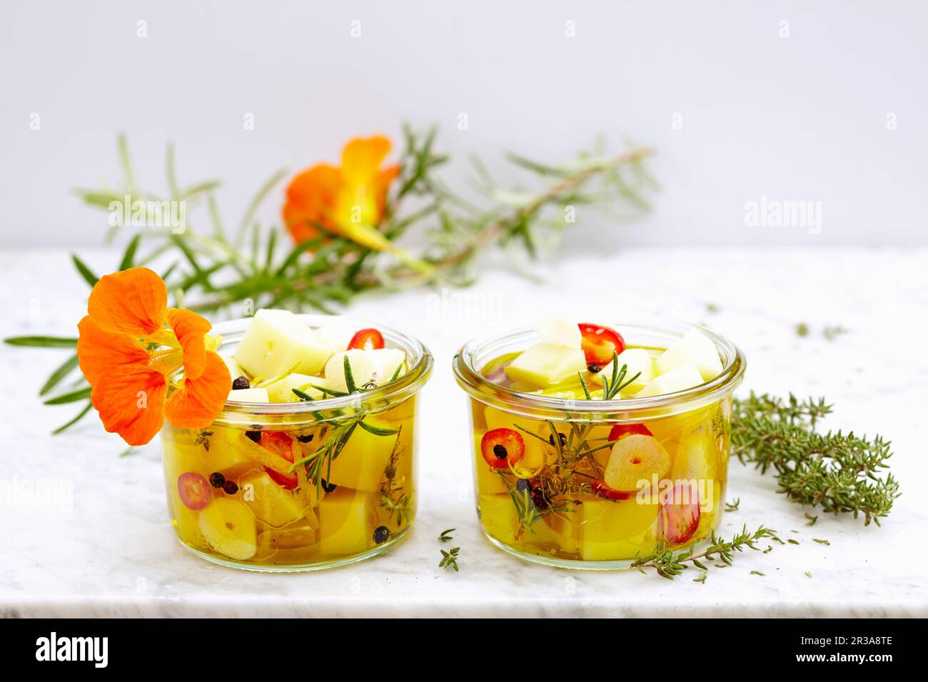 Eingelegtes Manchego mit Kräutern, Zitrone, Jalapenos und Knoblauch Stockfoto