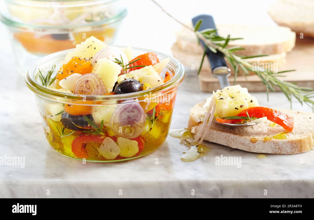 Eingelegter Manchego mit Paprika, Schalotten, Oliven und Brot Stockfoto