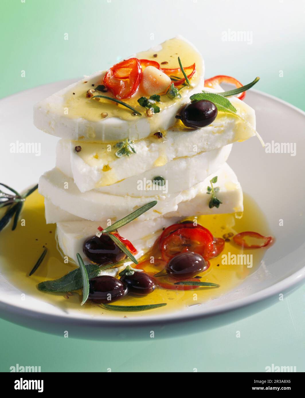 Marinierter Fetakäse mit Olivenöl, Chili, Oliven und Rosmarin Stockfoto