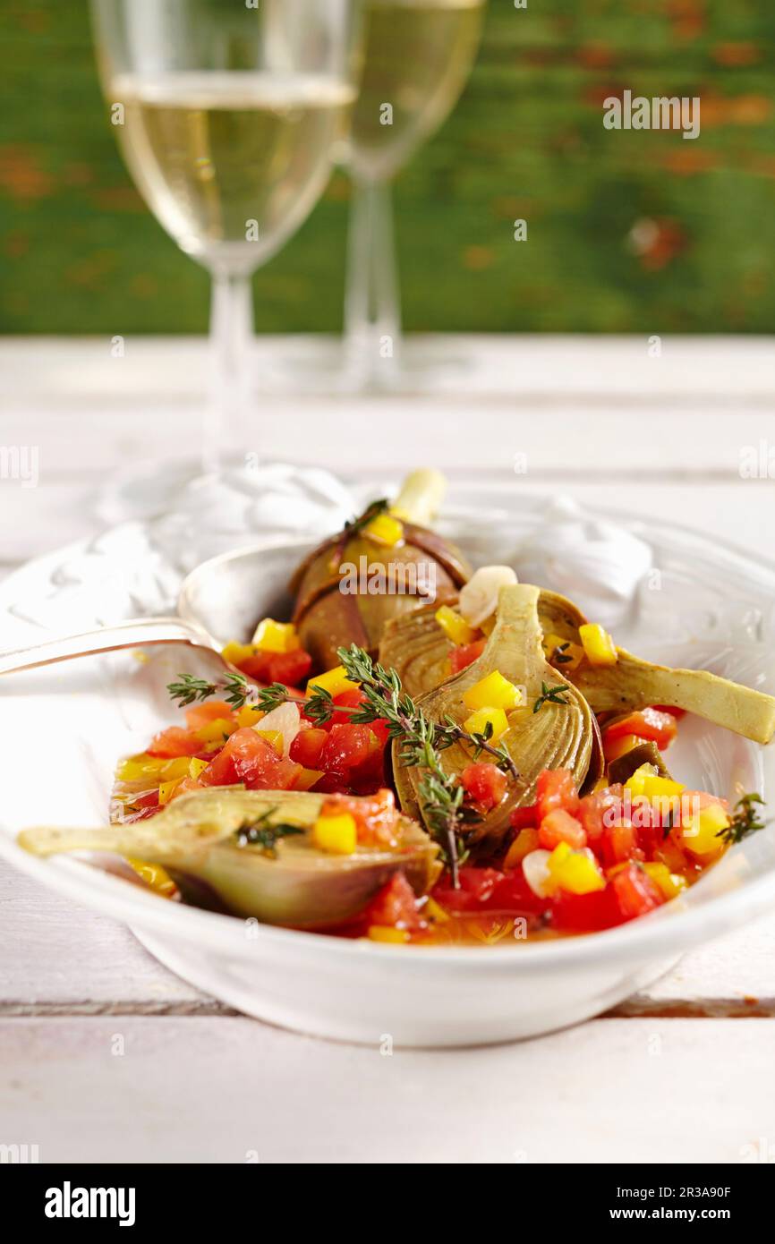 Junge eingelegte Artischocken mit Tomaten, Paprika, Essig, Öl, Zitrone, Weißwein und Gewürze Stockfoto