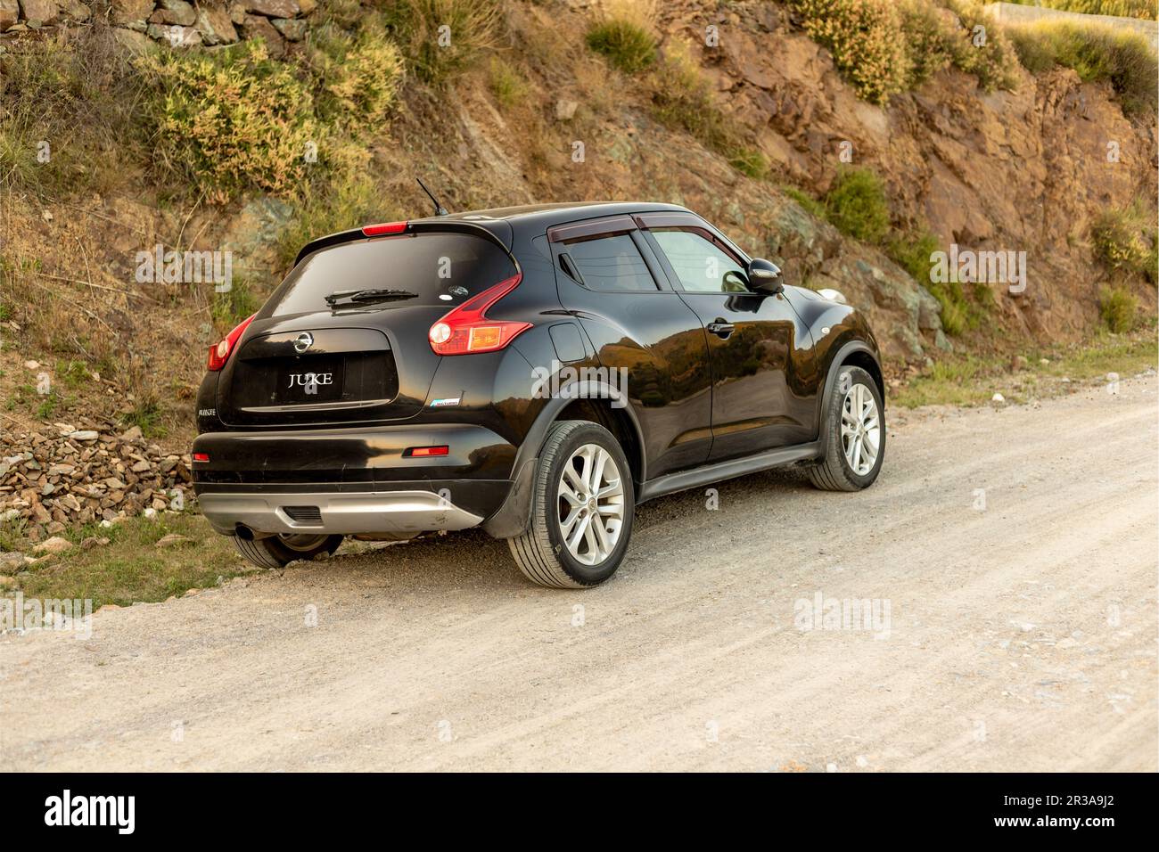 Schwarzer Nissan Juke parkt auf einer unbefestigten Straßenseite Stockfoto