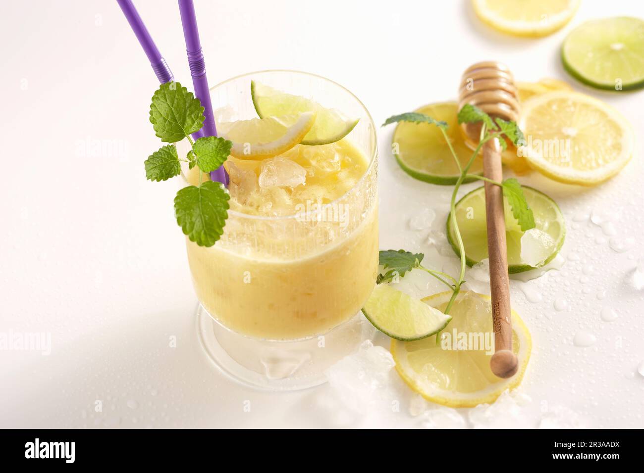 Mango-Reis-Shake mit Limette und Honig in einem Glas mit Trinkstroh Stockfoto