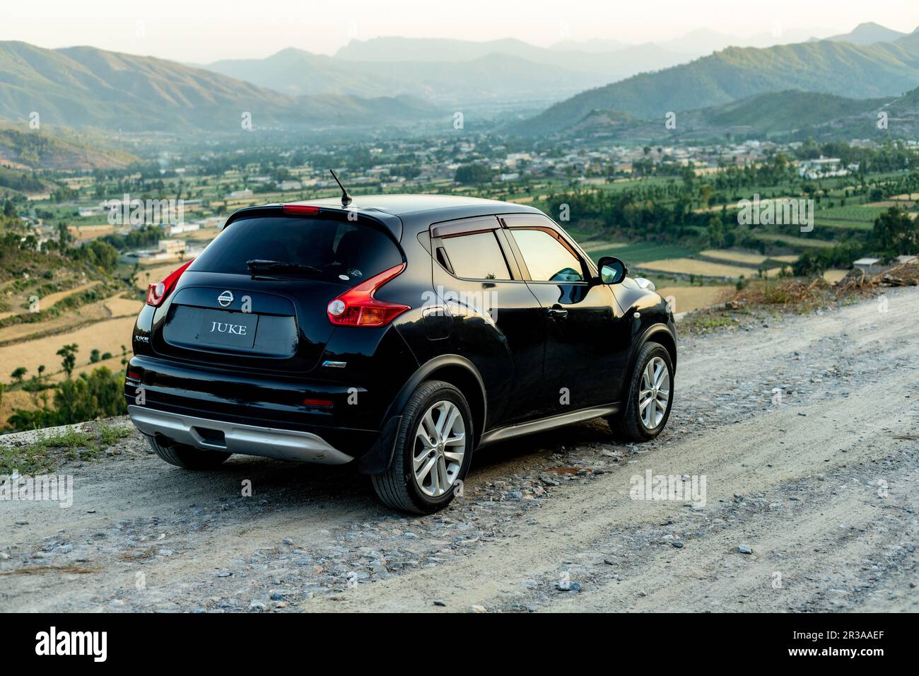 Nissan Juke parkte auf einer Schotterstraße mit einer wunderschönen Landschaft und Bergkulisse Stockfoto