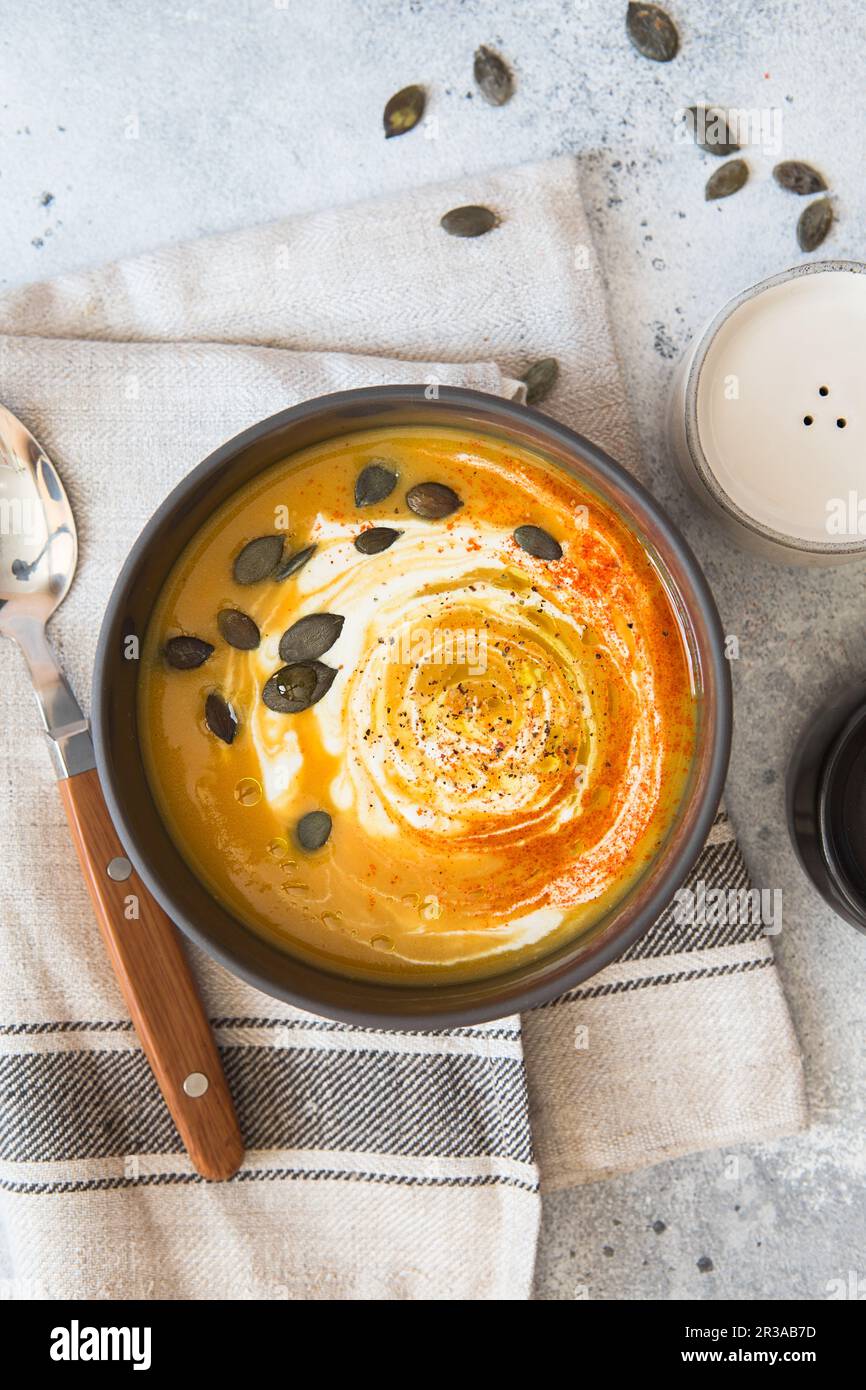 Kürbiscremesuppe. Geröstete Kürbis- und Karottensuppe mit Kurkuma, Sahne, Paprika, Schnittlauch und Stockfoto