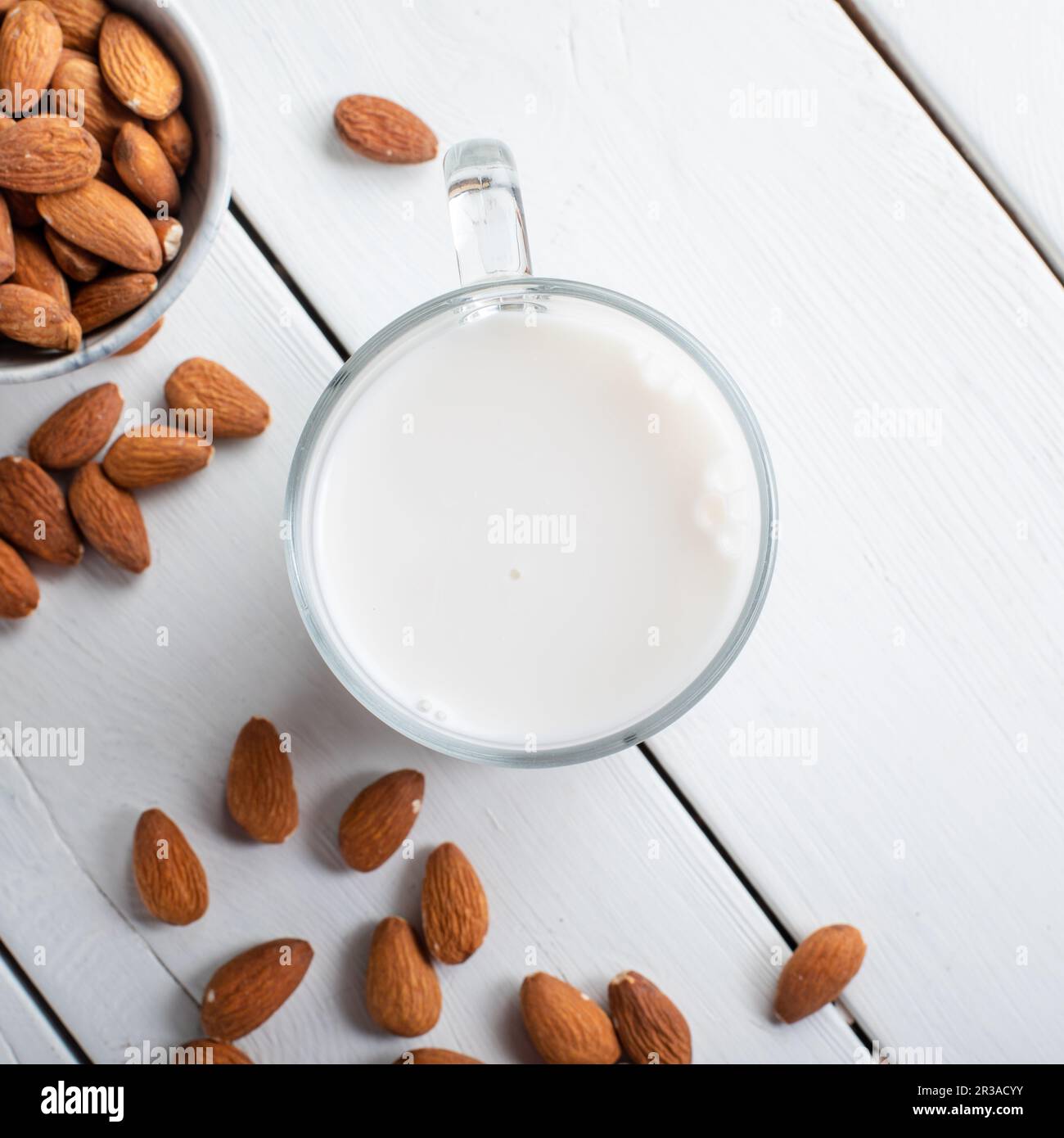 Mandelmilch aus Glas mit Mandeln auf hölzernen Hintergrund. Stockfoto