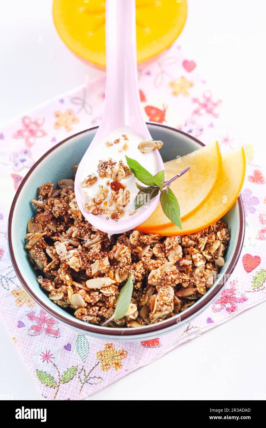 Geröstetes Müsli mit Amaranth, Sesamsamen, Sonnenblumenkernen und Honig, serviert mit Obst und Joghurt Stockfoto