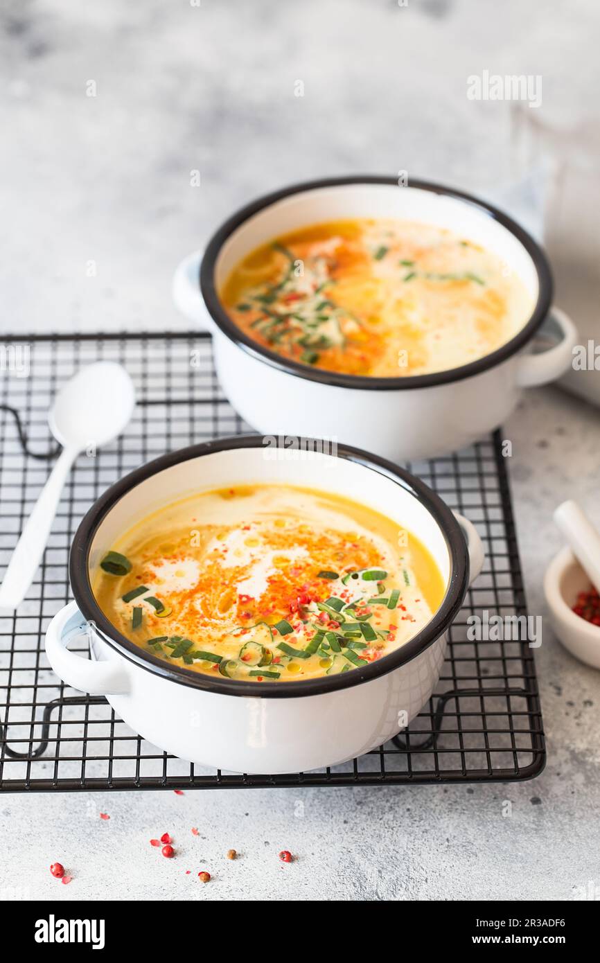 Kürbiscremesuppe. Geröstete Kürbis- und Karottensuppe mit Kurkuma, Sahne, Paprika, Schnittlauch und Stockfoto