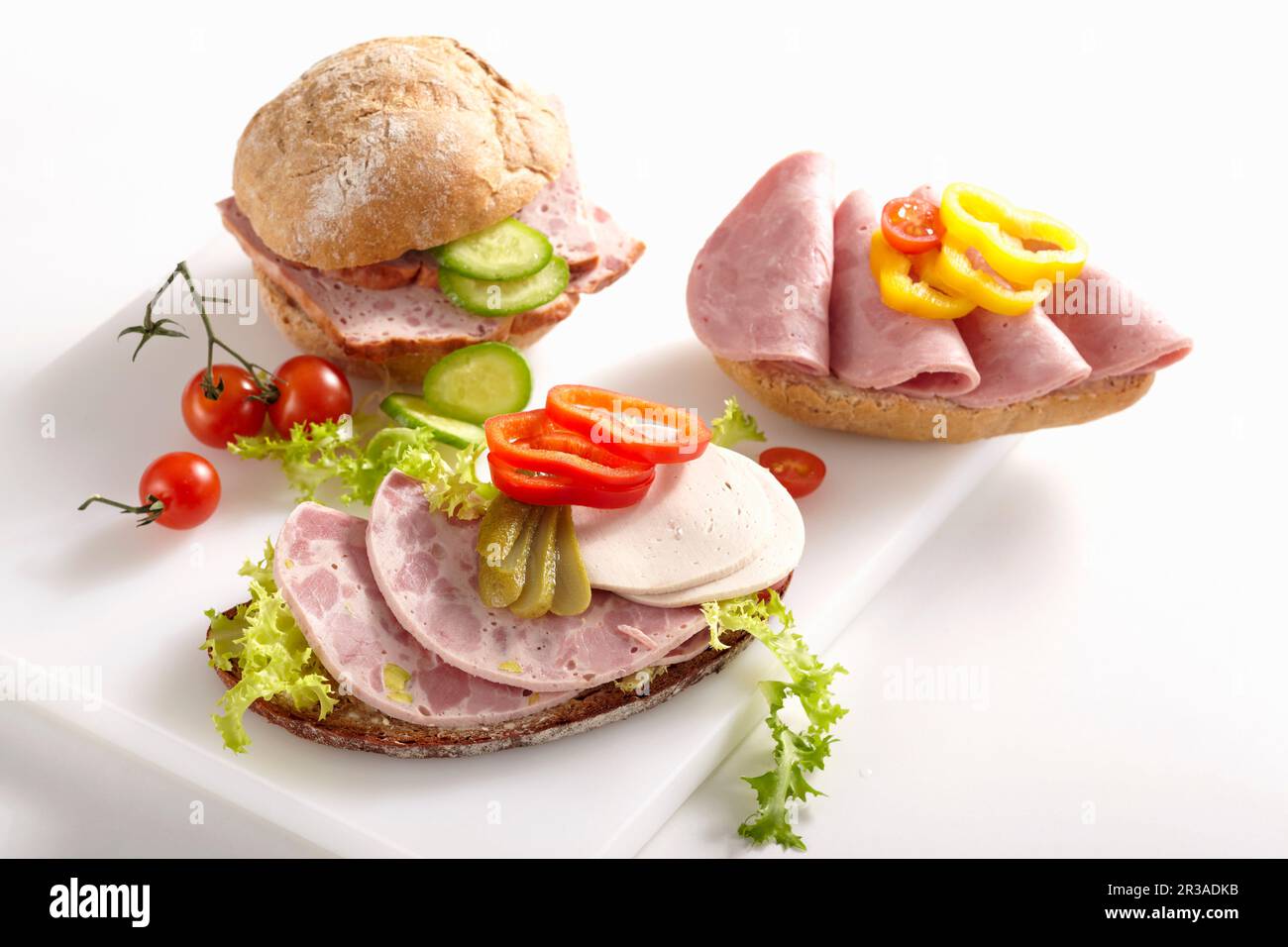 Wurstscheiben auf Brötchen mit Gemüse Stockfoto