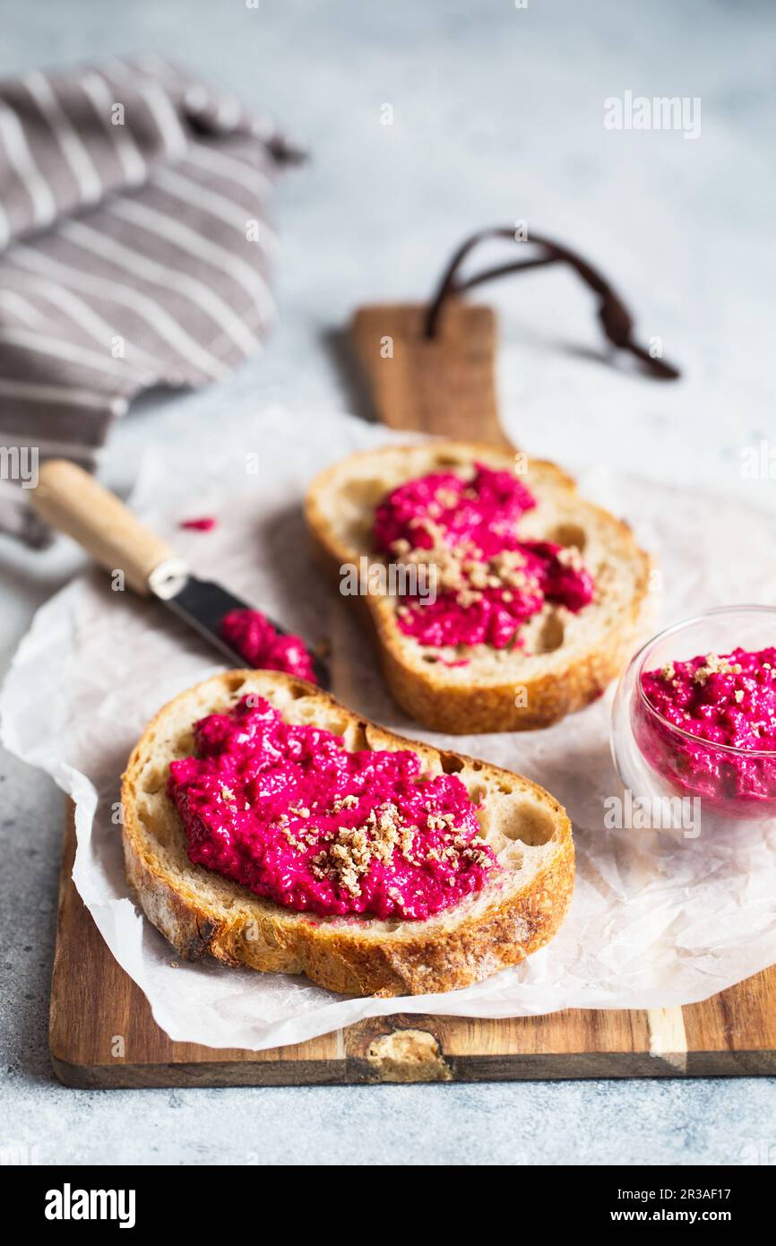 Bruschetta mit Rote-Bete-Hummus, verziert mit gehackten Nüssen und Mikrogrün. Vegane Rezepte, Pflanzenfresser Stockfoto