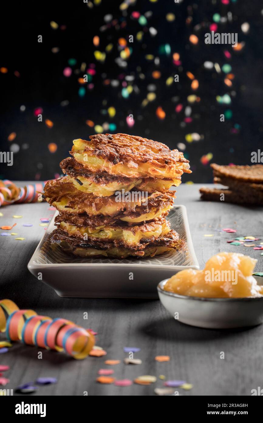 Ein Haufen Kartoffelfritter mit Apfelsauce und Karnevalsdekorationen Stockfoto