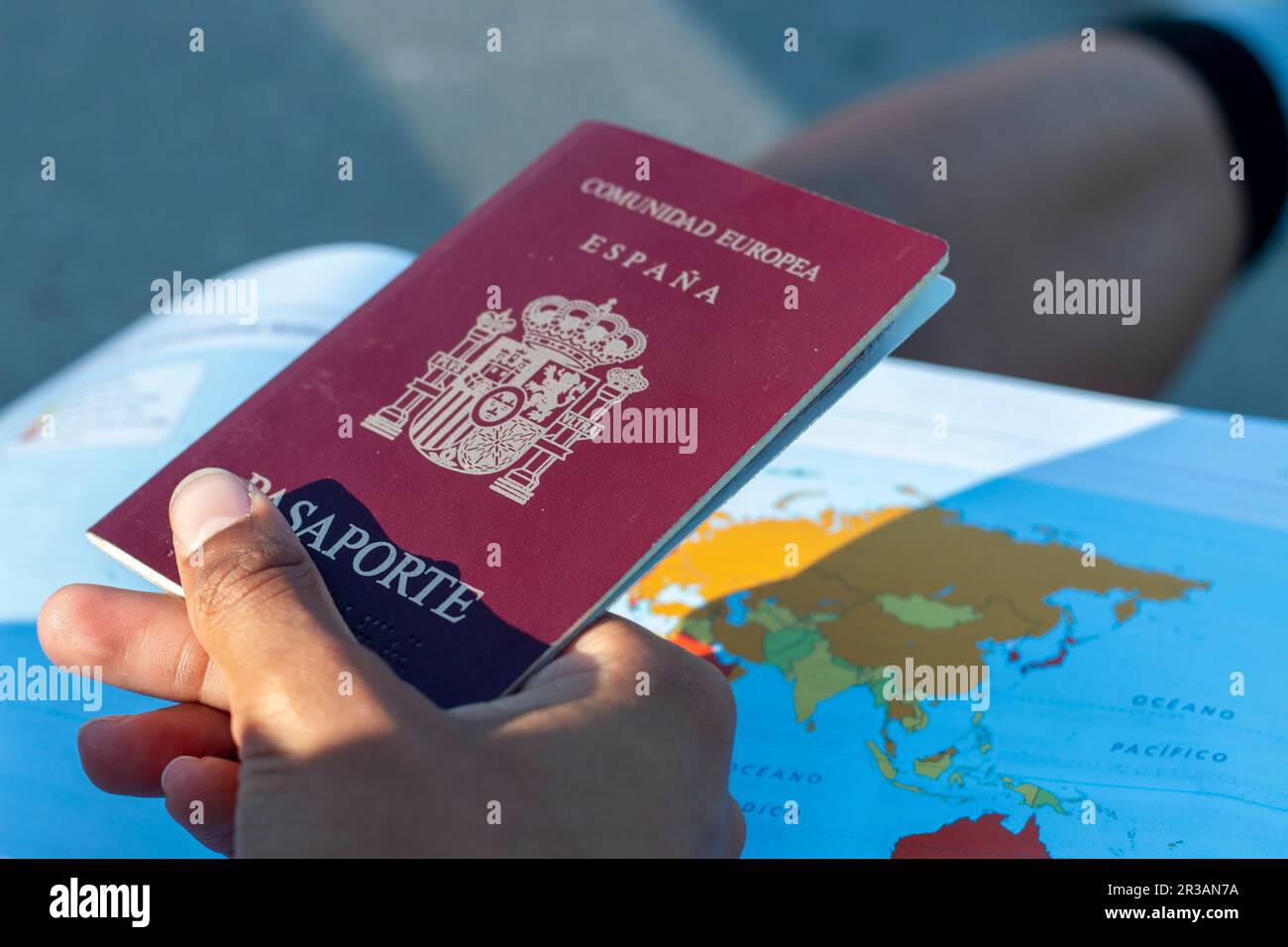 Reisepass der Europäischen Gemeinschaft, Spaniens. Mit dem Hintergrund einer Karte, einer stolzen Flagge, in einem Auto oder mit Sonnenbrille oder Hut Stockfoto