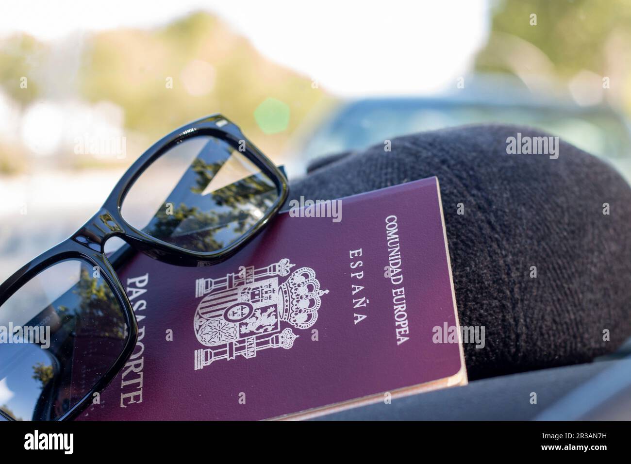 Reisepass der Europäischen Gemeinschaft, Spaniens. Mit dem Hintergrund einer Karte, einer stolzen Flagge, in einem Auto oder mit Sonnenbrille oder Hut Stockfoto