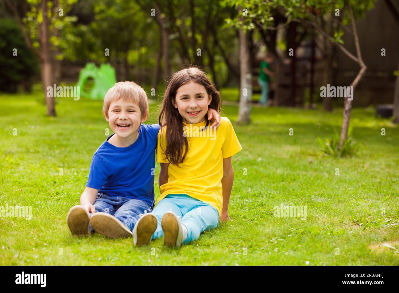 Der kleine Bruder und die Schwester haben Spaß beim Entspannen im Hinterhof Stockfoto