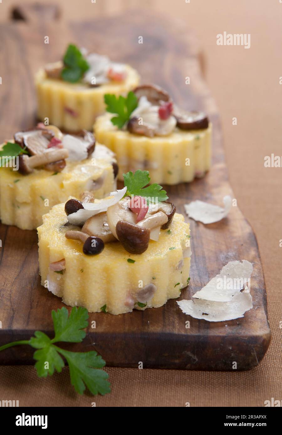Polenta-Törtchen mit Pilzen, Speck und Parmesan Stockfoto