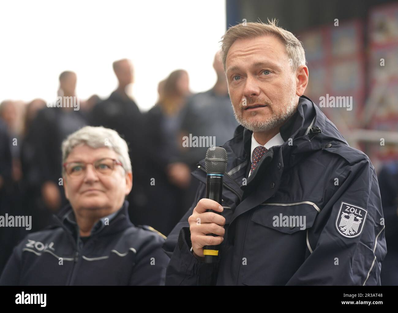 Hamburg, Deutschland. 23. Mai 2023. Christian Lindner (FDP, r), Bundesminister für Finanzen, trägt eine Zolljacke und steht neben Colette Hercher, Präsidentin der Generaldirektion Zoll, auf einer Pressekonferenz nach seinem Besuch bei der Zollabfertigung beim Hamburger Zollamt. Lindner legte die landesweite Bilanz von Zoll 2022 vor. Kredit: Marcus Brandt/dpa/Alamy Live News Stockfoto
