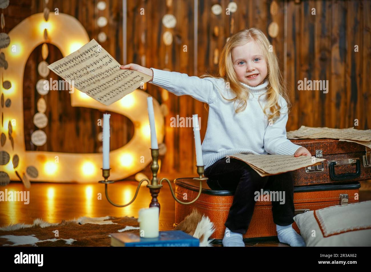 Blonde kleine Mädchen hält eine Notiz im Vintage-Interieur Stockfoto
