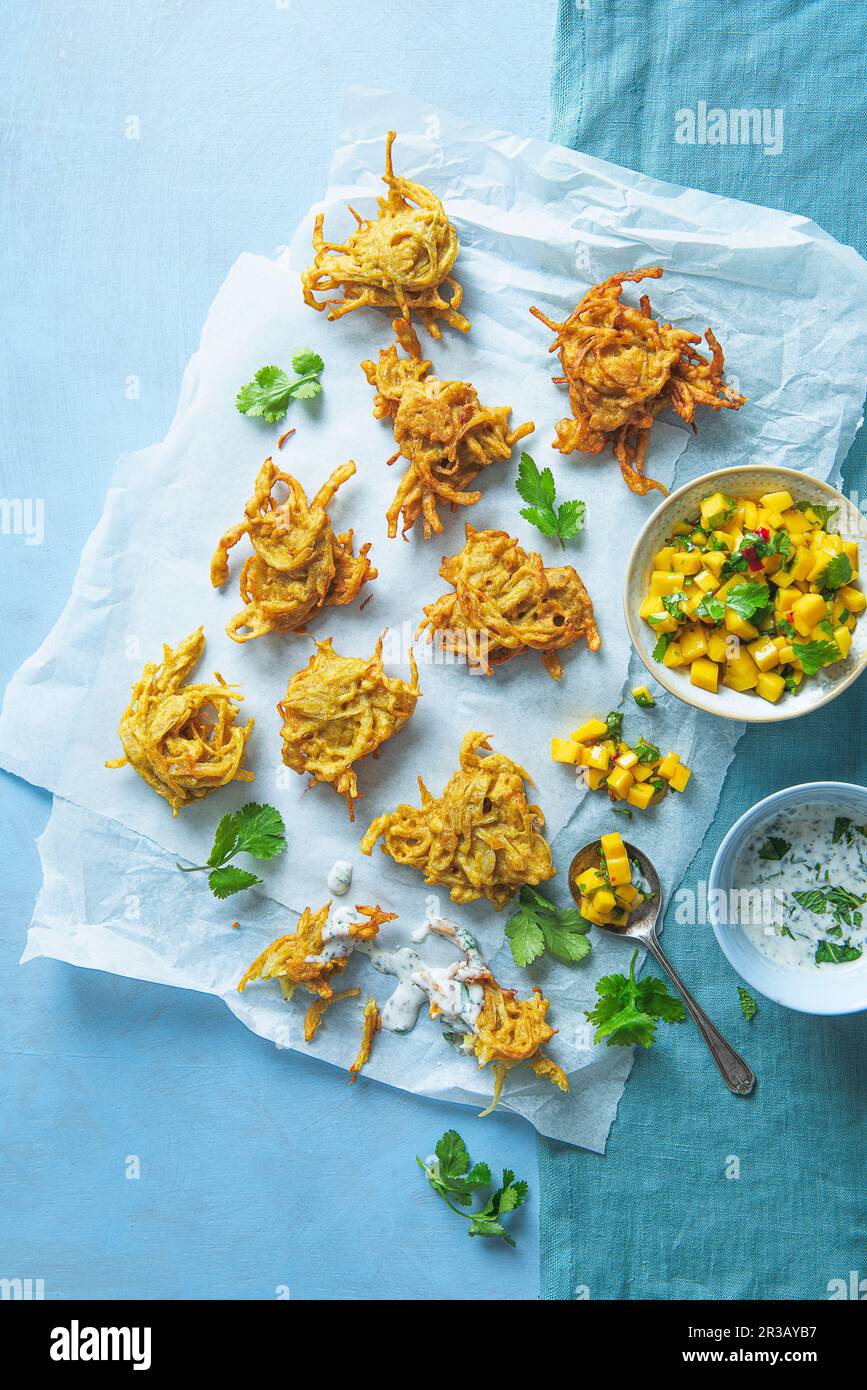 Indische frittierte Zwiebeln Bhajis (vegan) mit Mango-Relish und Kokosnuss-Minze-Dip Stockfoto