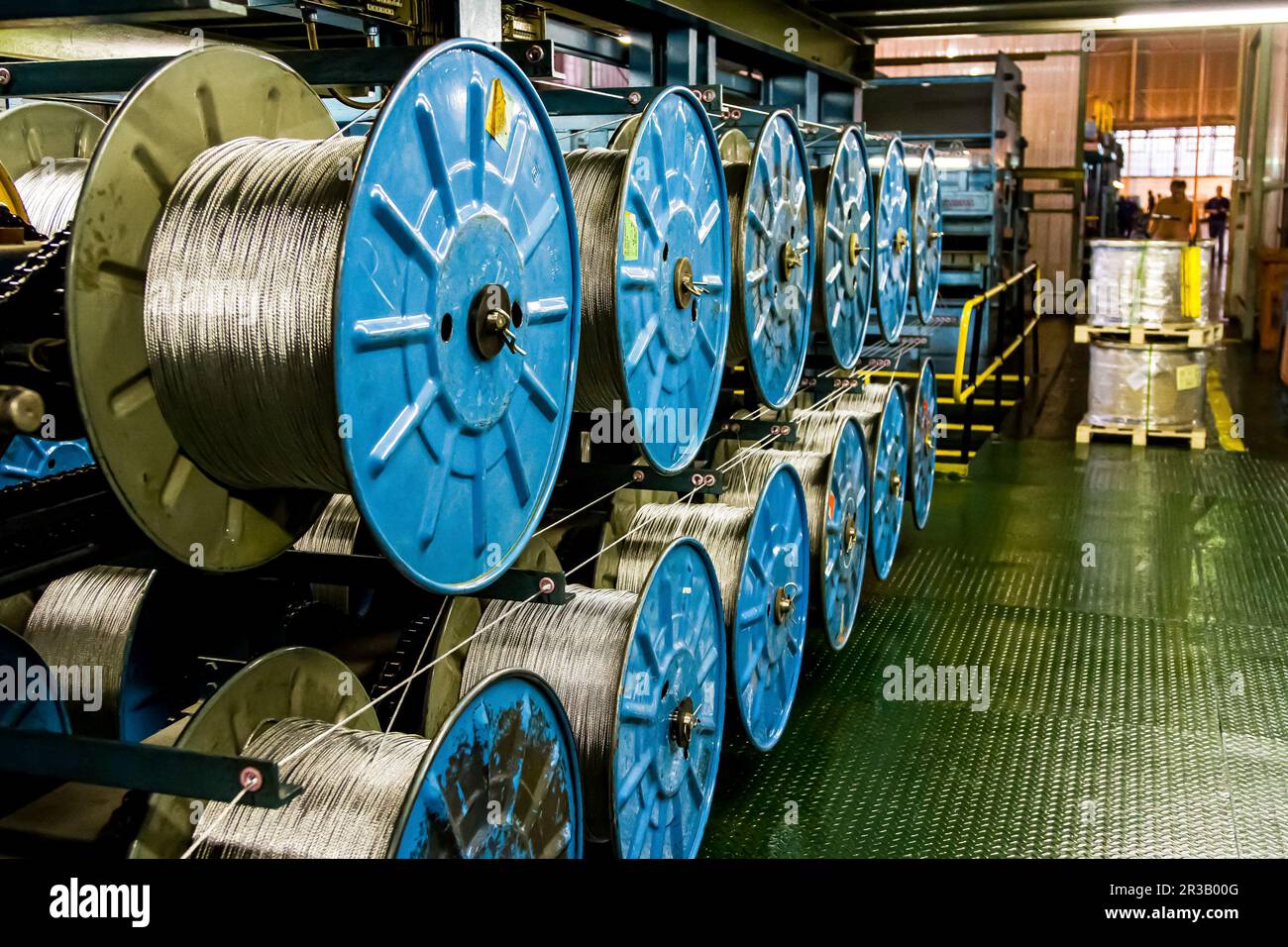 Nahaufnahme der Kabelspulen einer großen Maschine in einer Förderbandfabrik Stockfoto