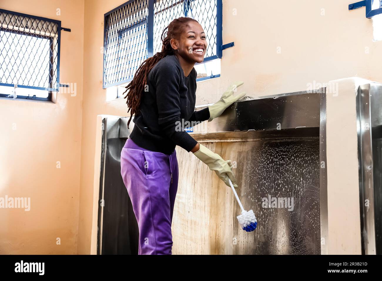 Diverse Frauen, die ehrenamtliche Reinigungsarbeiten in der Township-Schule durchführen Stockfoto