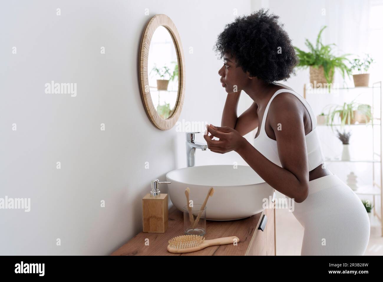 Junge Frau im Spiegel im Badezimmer suchen Stockfoto