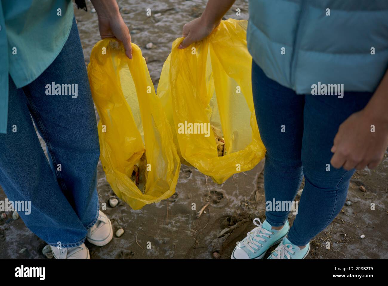 Aktivisten halten Plastiktüten mit Müll am Strand Stockfoto