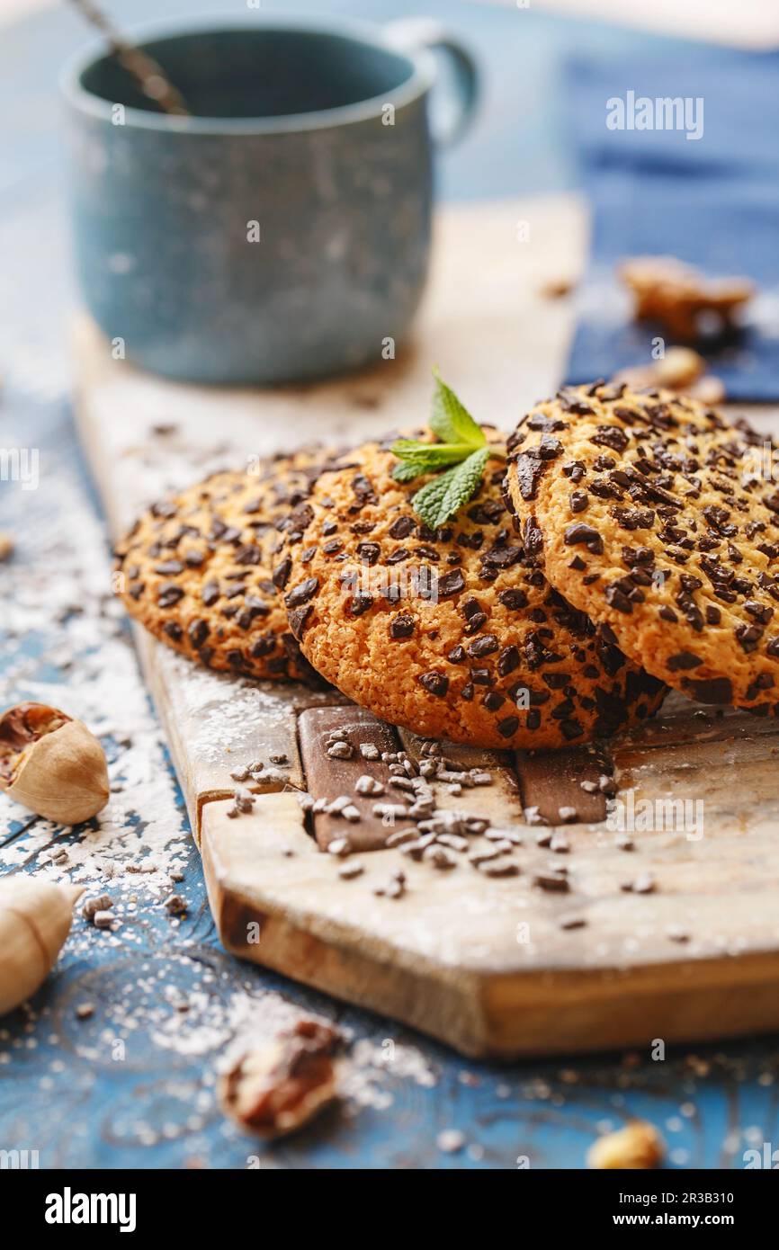 Kekse mit Schokoladenstückchen auf dem Holzbrett. Mystic Light Food Fotografie. Stockfoto