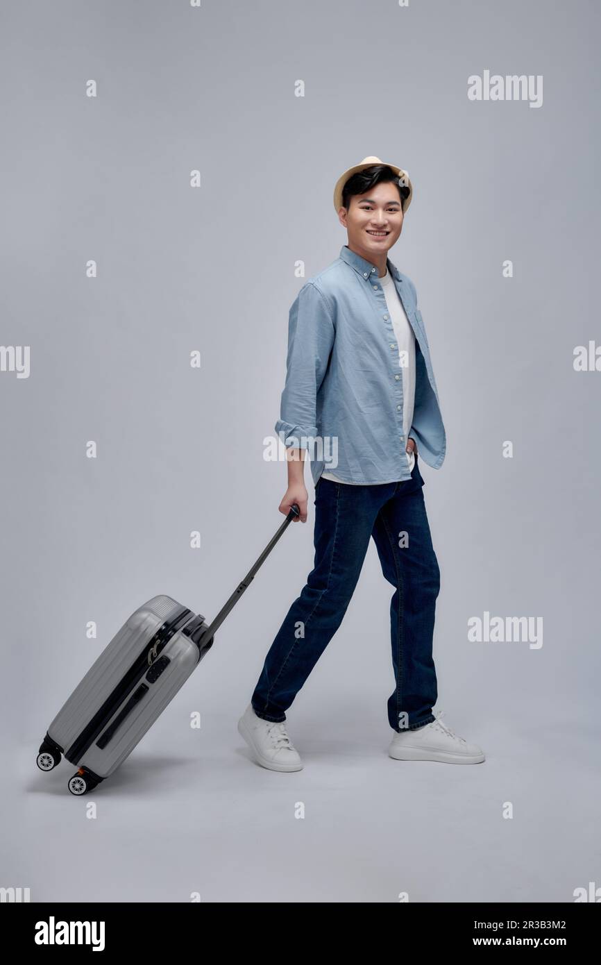 Glücklicher junger asiatischer Tourist mit Gepäck, der in den Urlaub reist Stockfoto