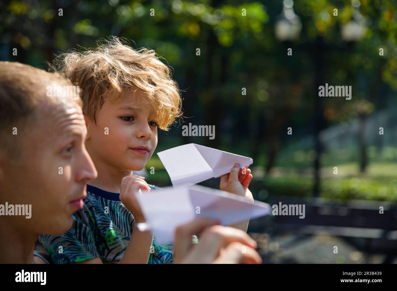 Sohn und Vater spielen mit Papierflugzeugen Stockfoto