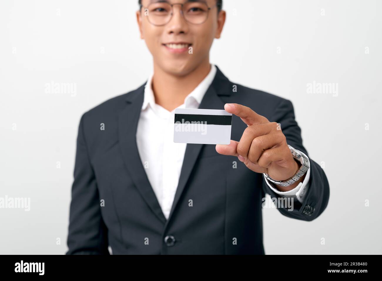 Foto eines attraktiven jungen Mannes mit Kreditkarte isoliert auf weißem Hintergrund Stockfoto