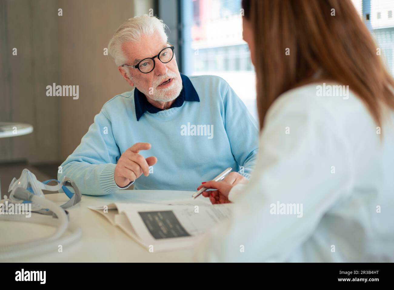 Seniorpatientengespräch mit dem Arzt an der Praxis im Krankenhaus Stockfoto