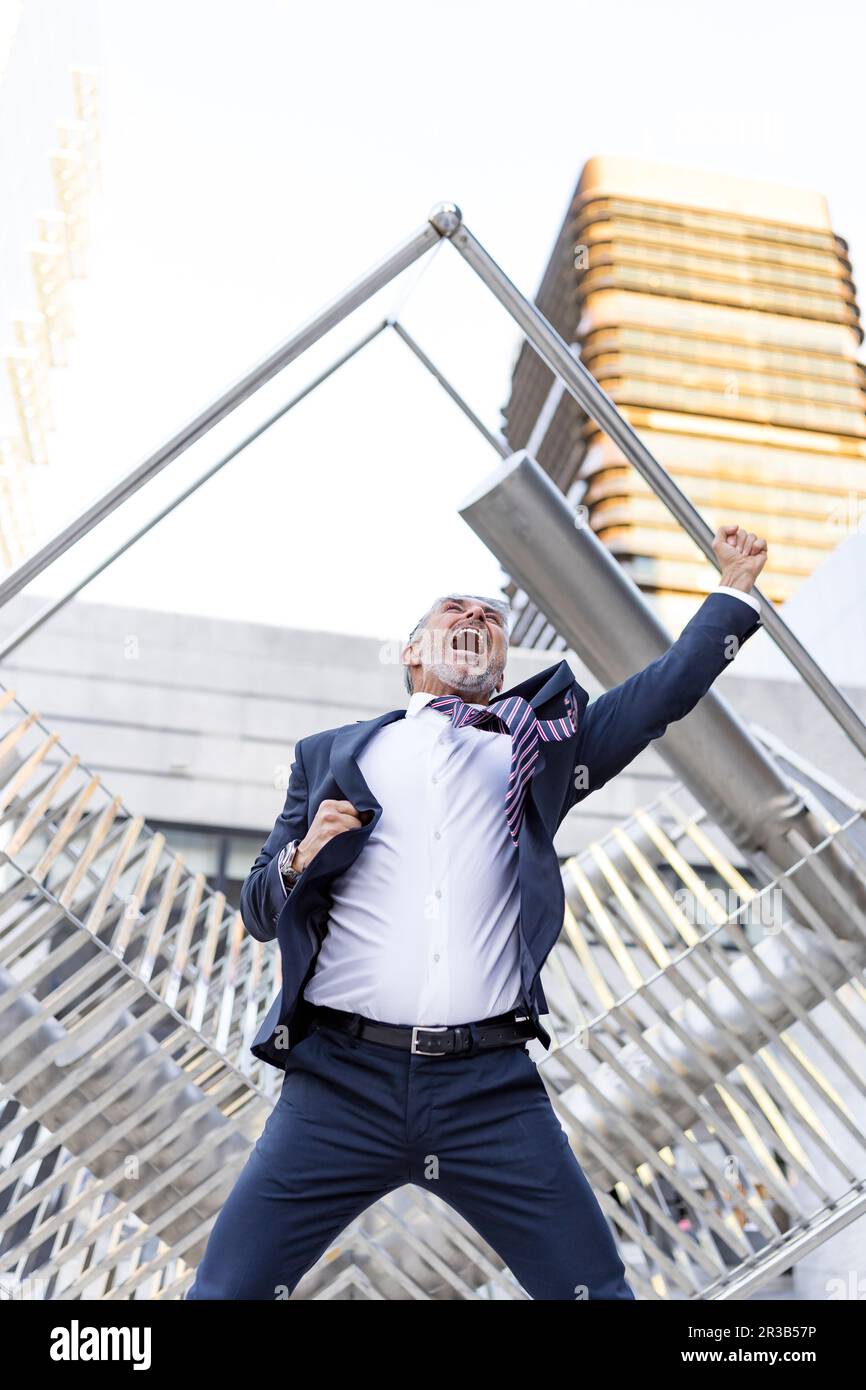 Fröhlicher Geschäftsmann, der vor dem Gebäude schreit Stockfoto