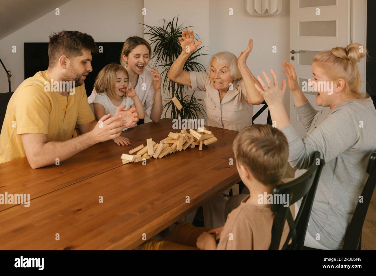 Familien, die zu Hause Freizeitspiele für mehrere Generationen spielen Stockfoto