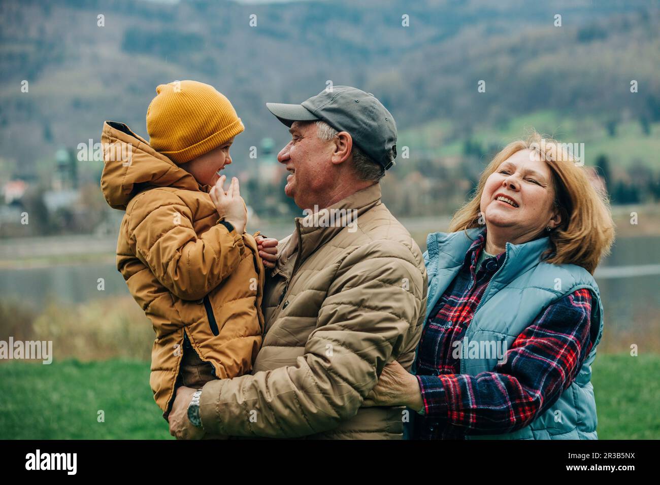 Großeltern haben Spaß mit Enkel in warmer Kleidung Stockfoto