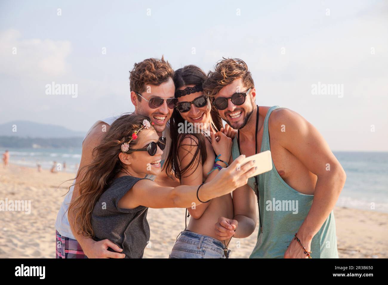 Glückliche Frau, die Selfie mit Freunden im Urlaub am Strand macht Stockfoto