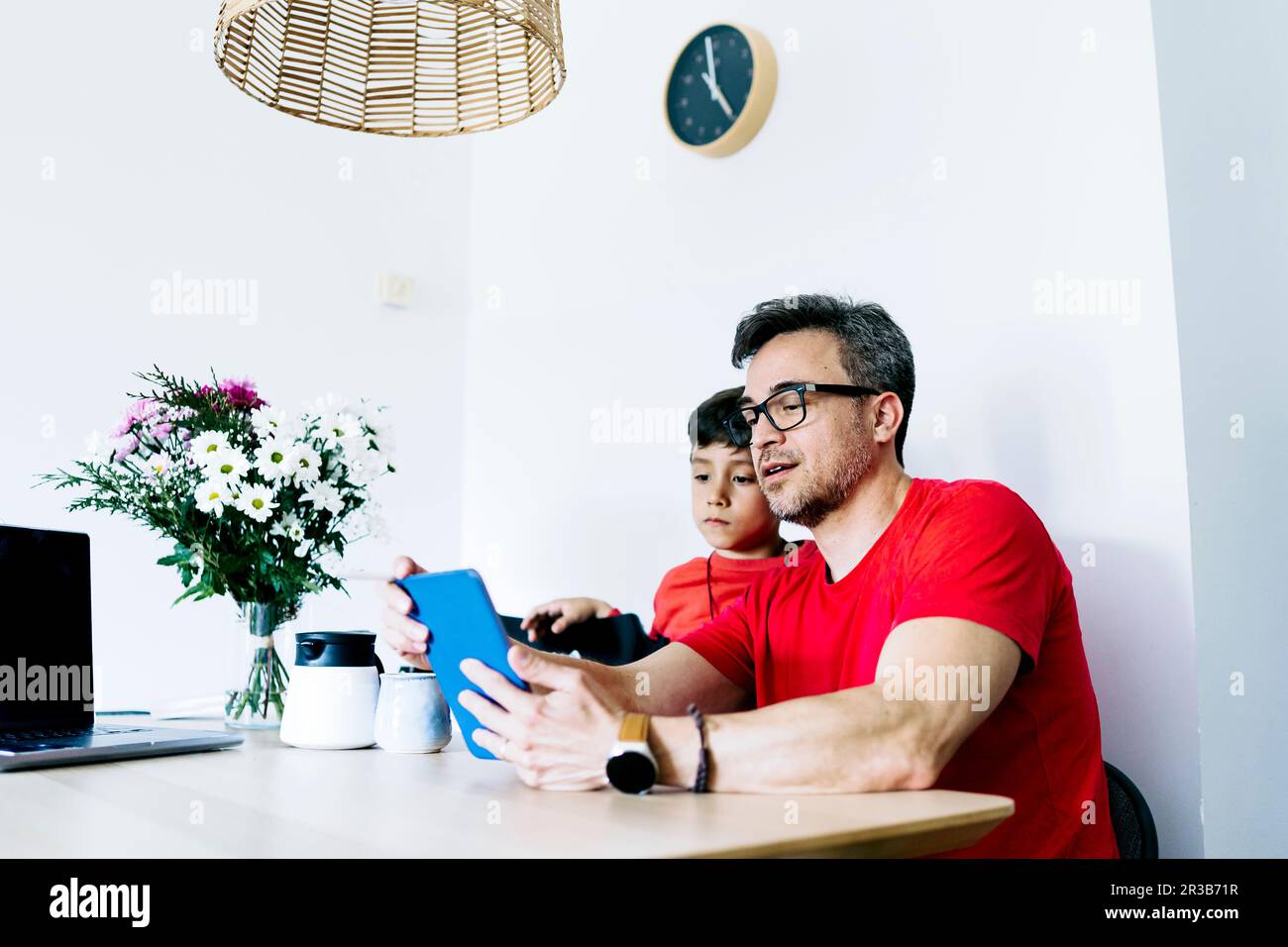 Vater teilt Tablet-PC mit Sohn zu Hause Stockfoto