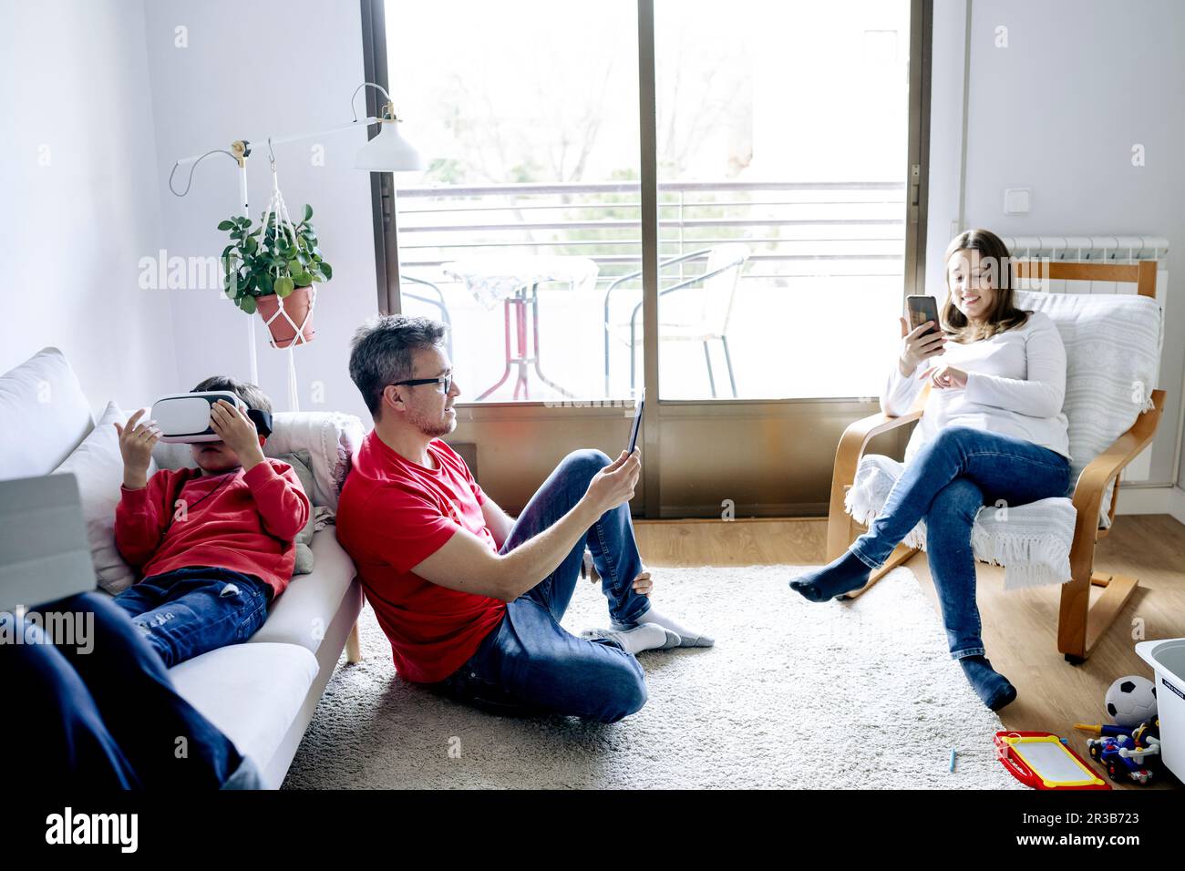 Familie, die zuhause kabellose Technologien im Wohnzimmer nutzt Stockfoto