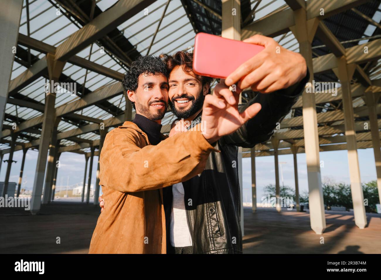Schwule Männer machen Selfie durch Smartphone unter Betonstruktur Stockfoto