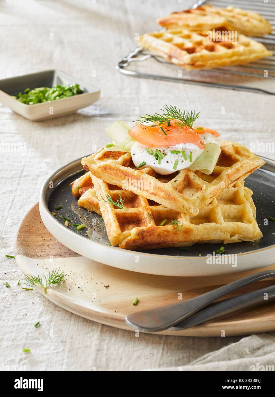 Kartoffelwaffeln mit Lachs, Sauerrahm, Gurke, Dill und Schnittlauch Stockfoto