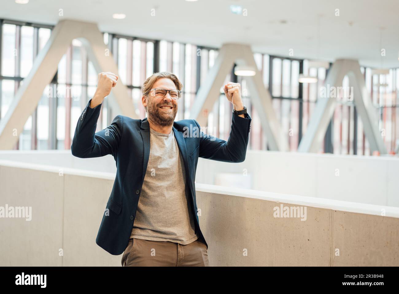 Ein fröhlicher Geschäftsmann, der im Büro die Fäuste kneift Stockfoto