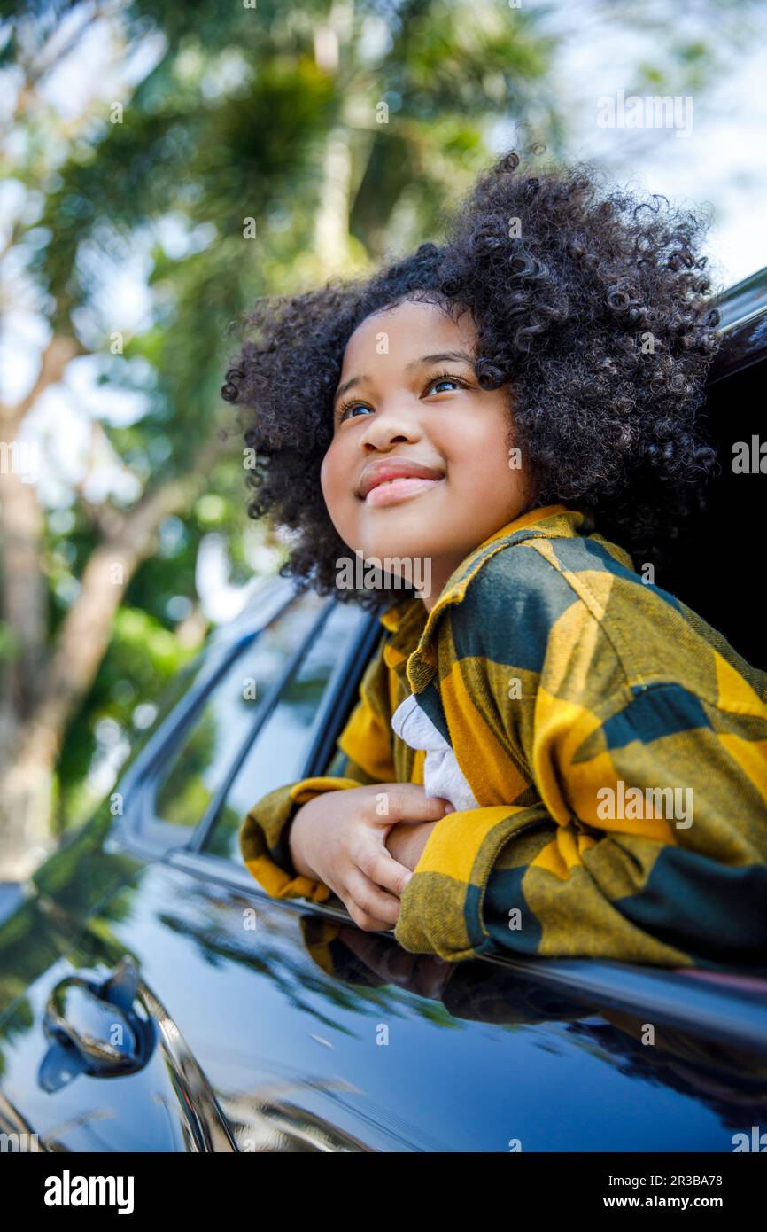 Lächelndes Mädchen, das im Auto nachdenkt Stockfoto