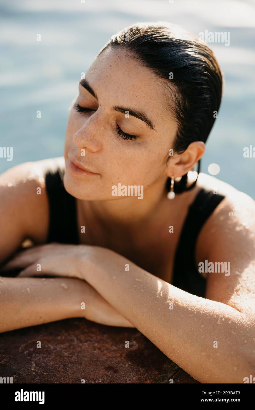 Frau mit nassen Haaren, entspannend am Pool Stockfoto
