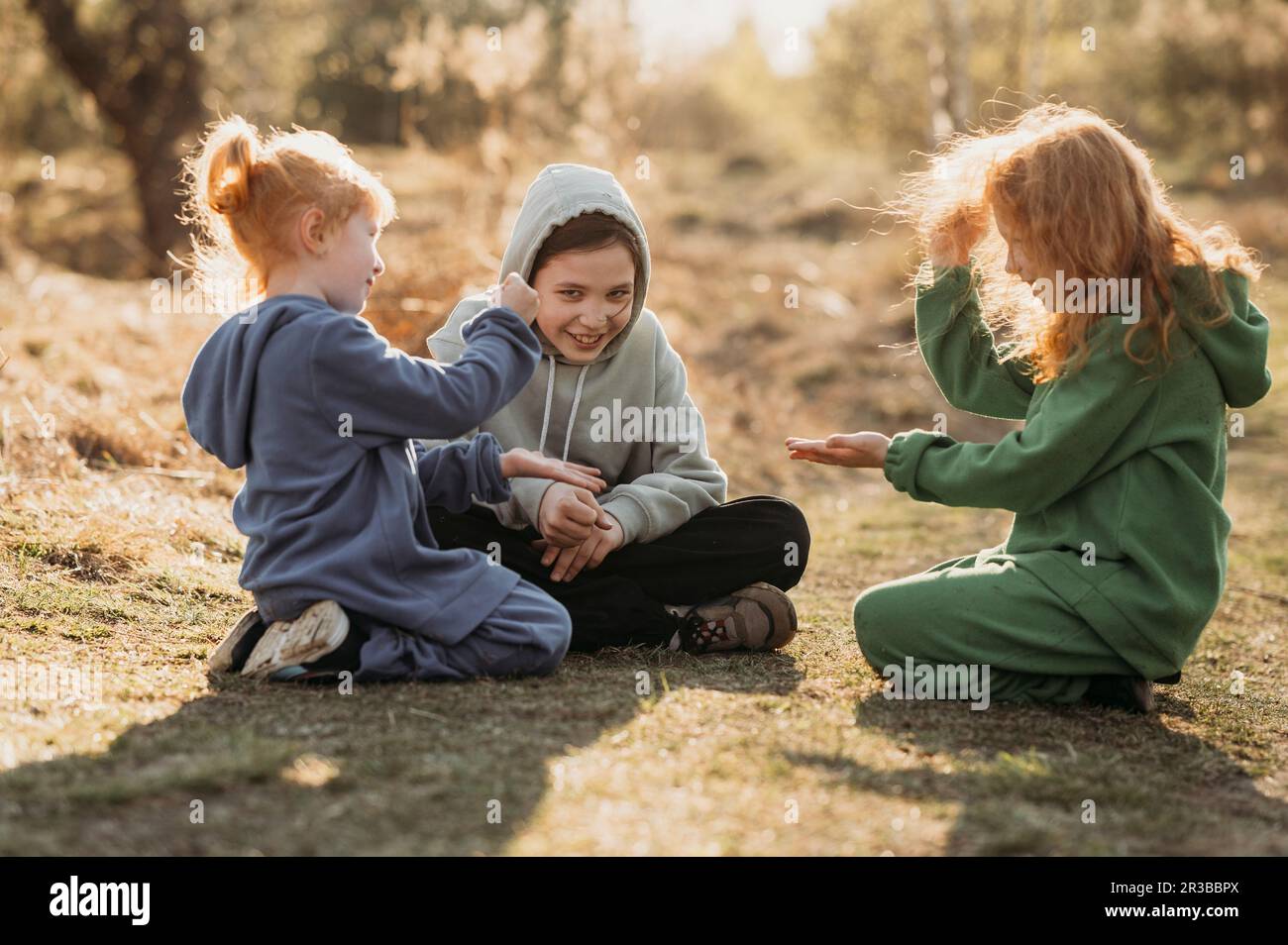 Kinder, die an sonnigen Tagen beim Aufräumen im Wald spielen Stockfoto