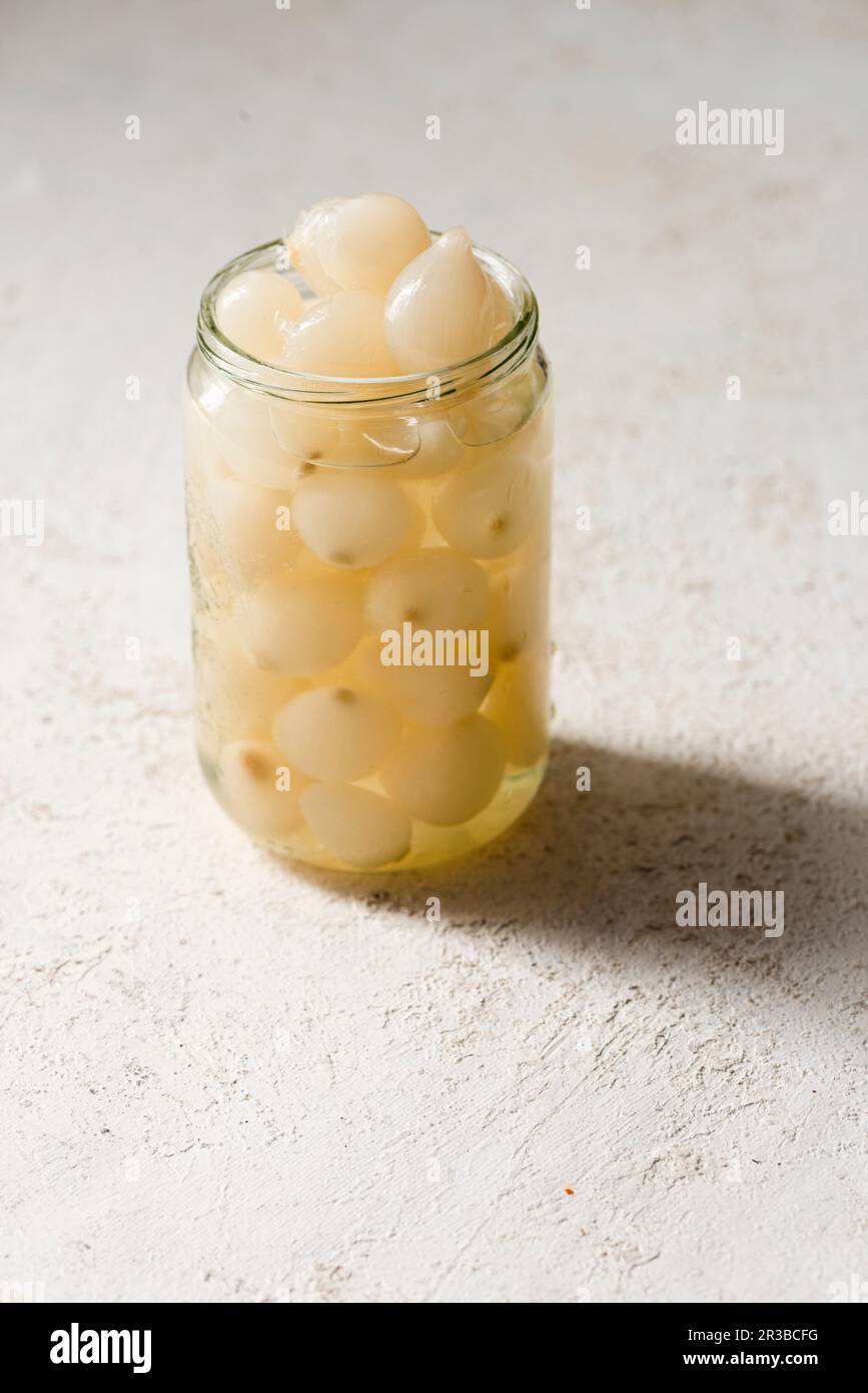 Eingelegte kleine Zwiebeln in einem Glas Stockfoto