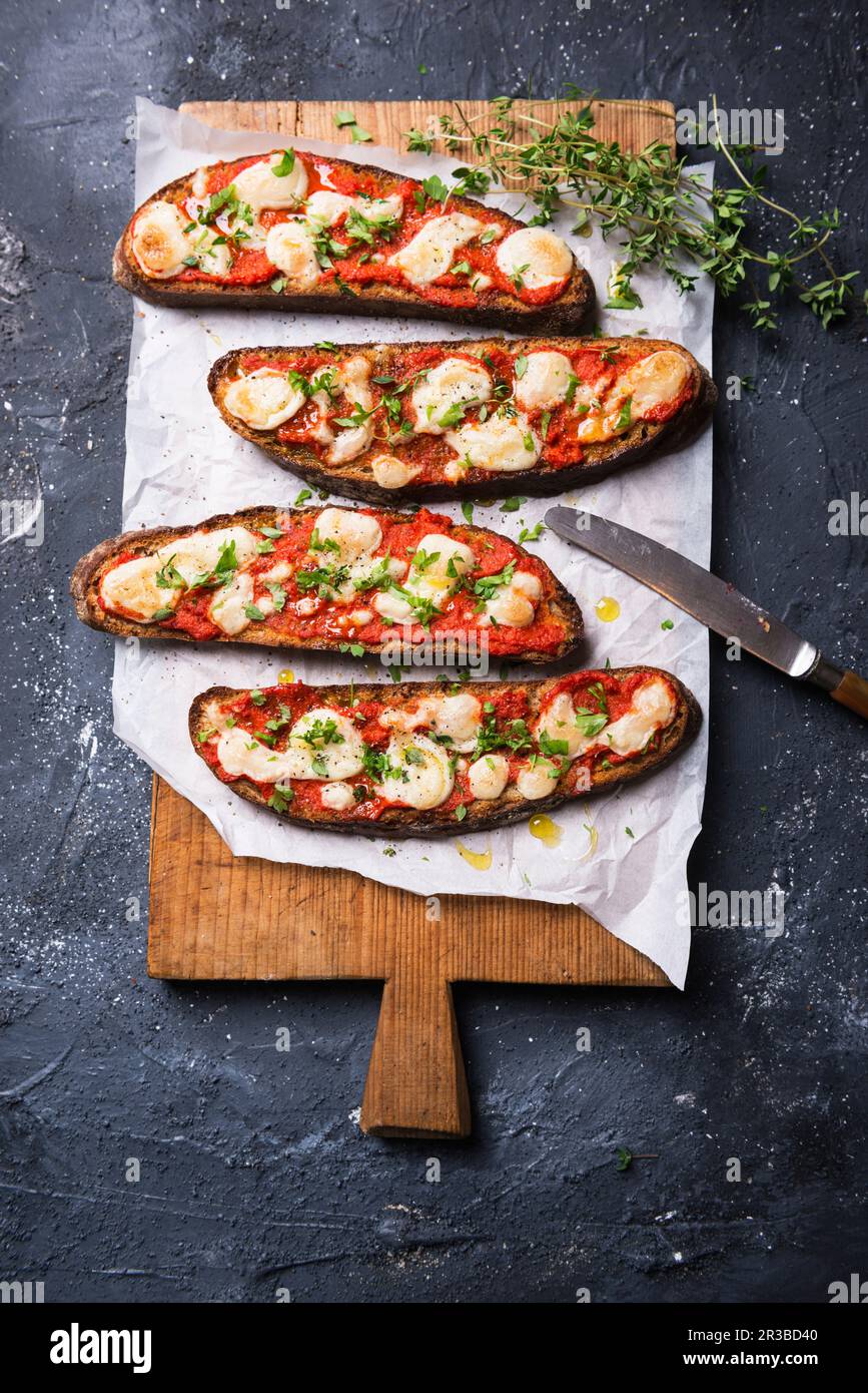 Gebackenes geräuchertes Mehlbrot mit Ajvar (Pfefferpaste) und veganem Mandelkäse Stockfoto