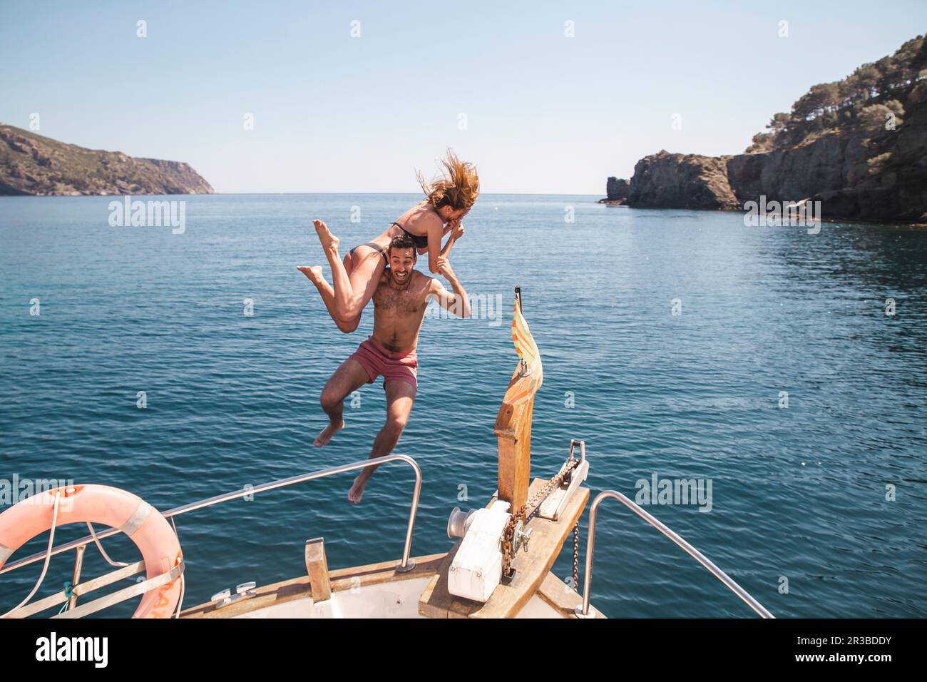 Mann und Frau, die im Urlaub vom Boot ins Meer springen Stockfoto