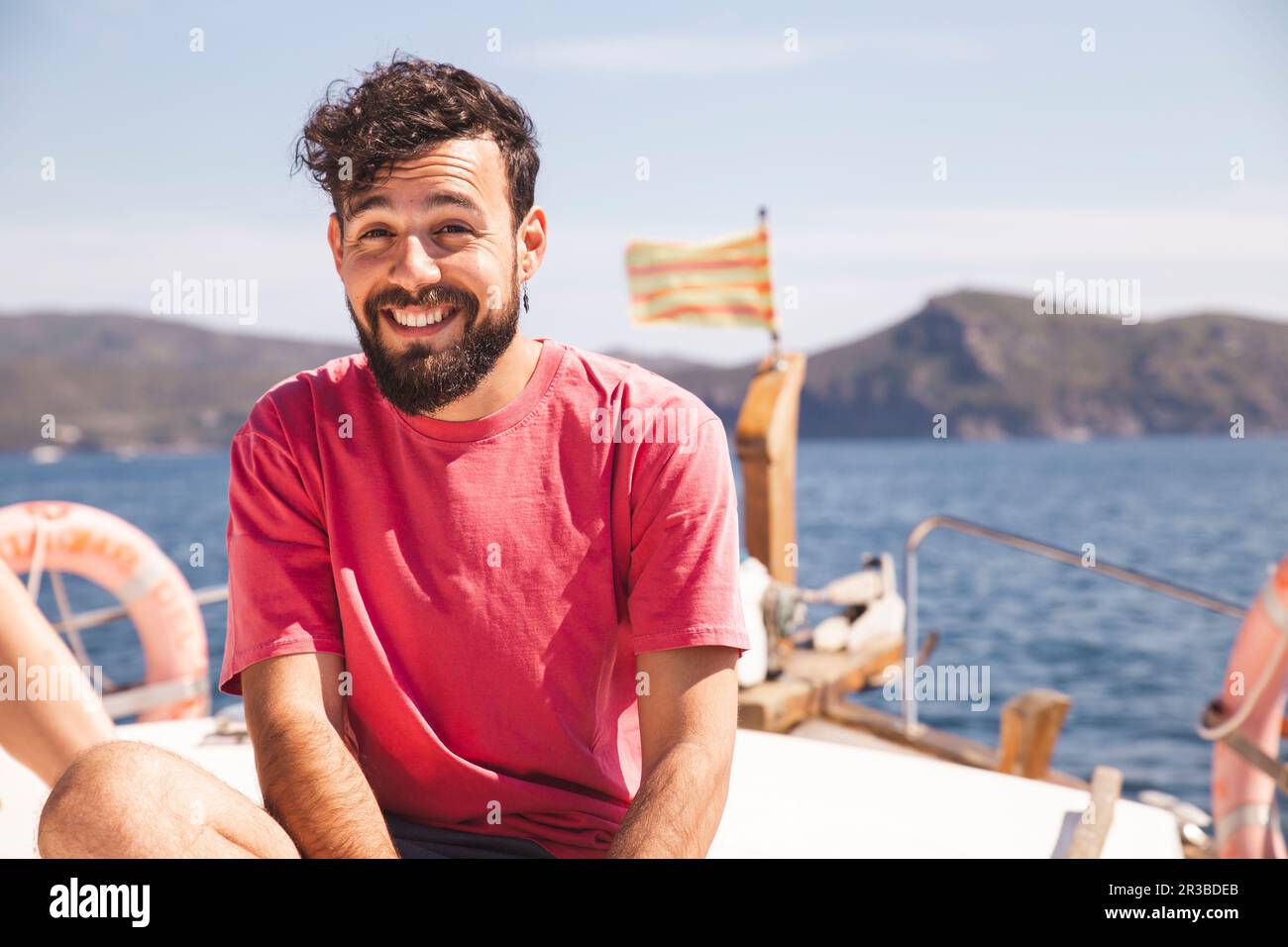 Lächelnder Mann, der an sonnigen Tagen Urlaub auf der Yacht genießt Stockfoto