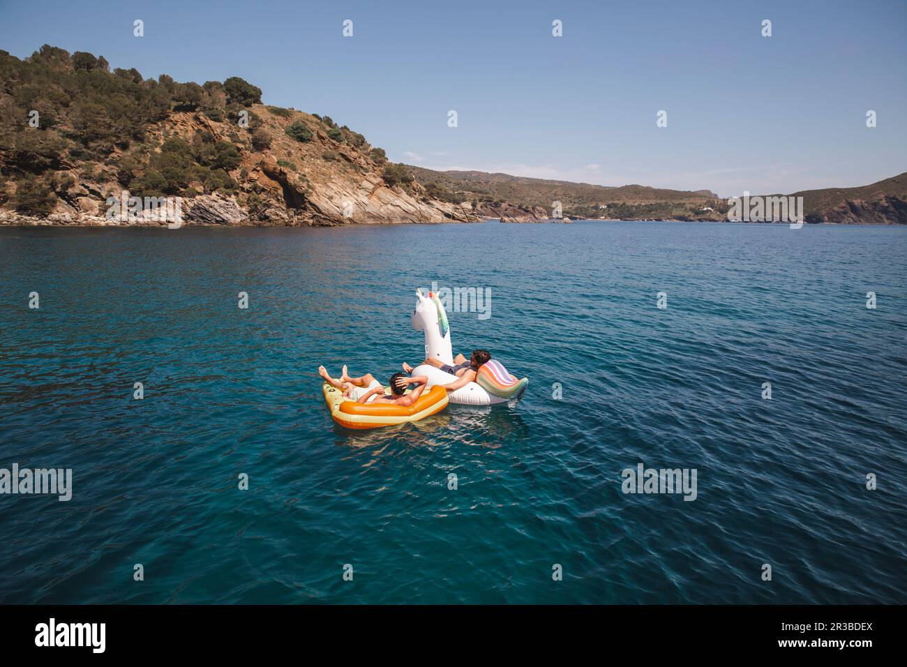 Männer, die ihren Urlaub auf Luftmatratzen im Meer genießen Stockfoto