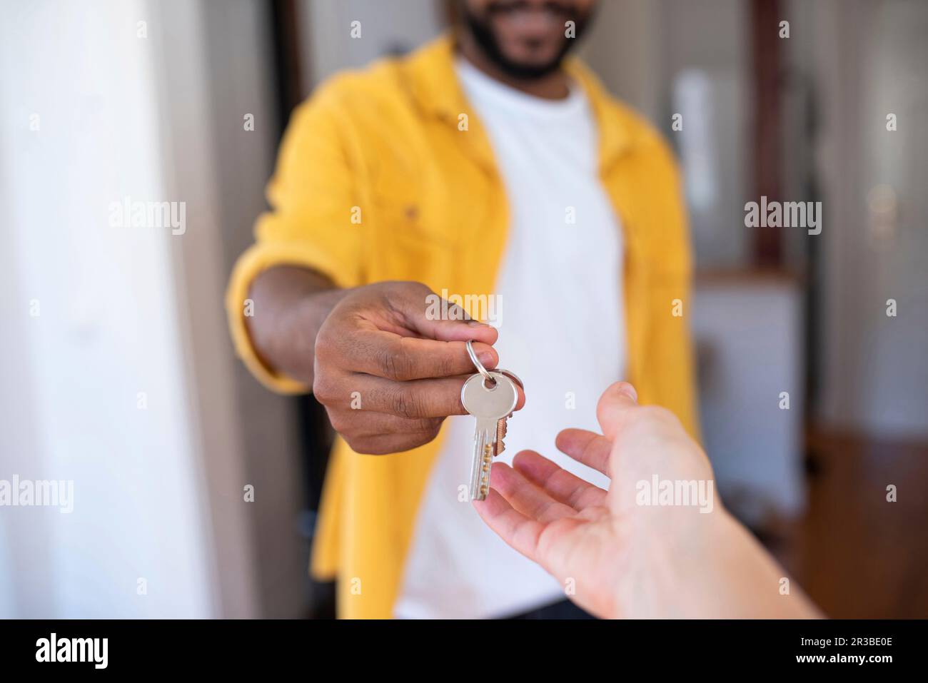 Immobilienmakler gibt dem Mann Hausschlüssel Stockfoto