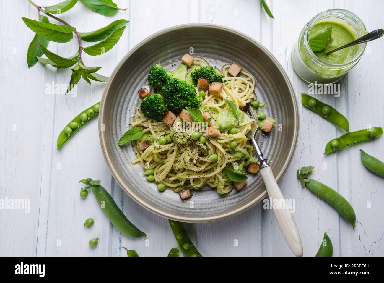 Spaghetti mit Erbsen und Minzpesto, Brokkoli und geräuchertem Tofu Stockfoto