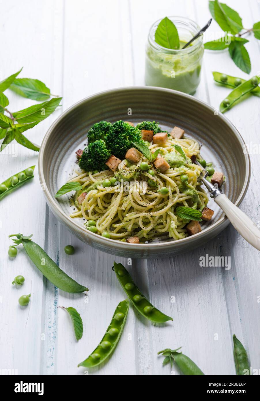 Spaghetti mit Erbsen und Minzpesto, Brokkoli und geräuchertem Tofu Stockfoto